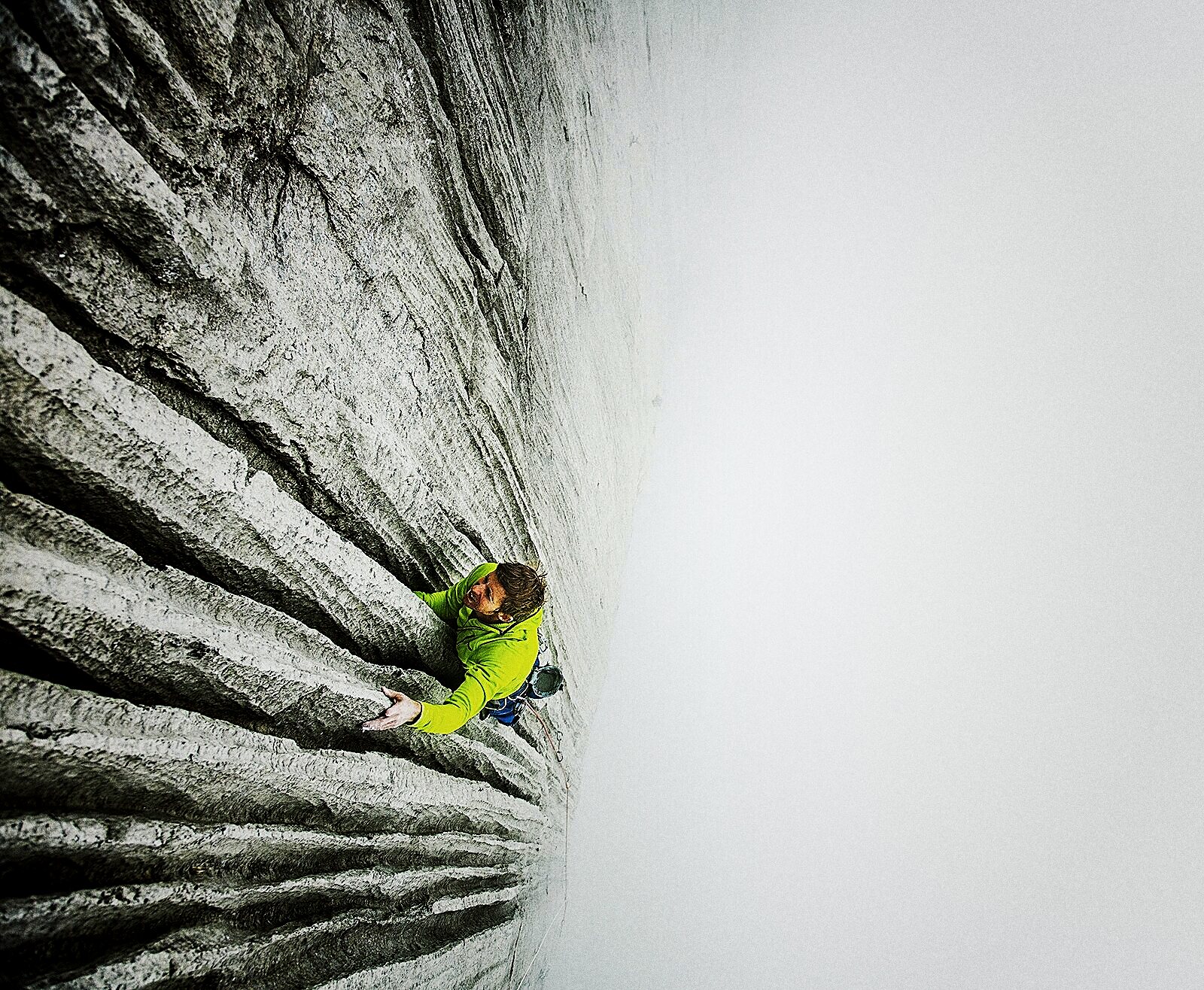 Tommy Caldwell, a small figure in yellow, high on the pale granite of the Dawn Wall, El Capitan